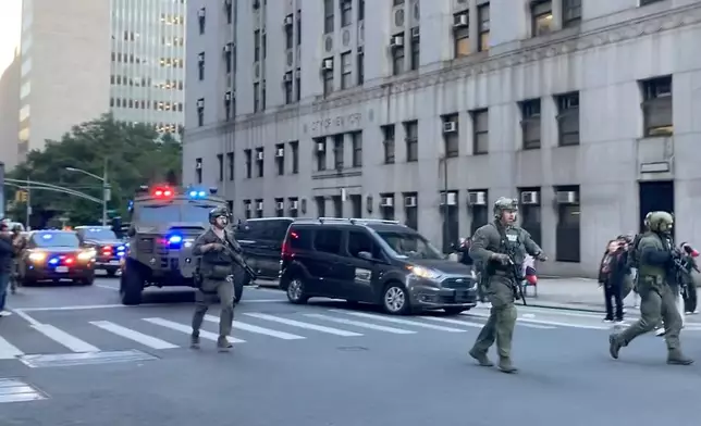 Federal agents walk down Lafayette Street as demonstrators follow along after an immigration sweep on Canal Street through Chinatown, Tuesday, Oct. 21, 2025, in New York. (AP Photo/Jake Offenhartz)