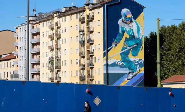 A giant mural depicting a skier is displayed on a wall of a building next to the Olympic village, in Milan, Italy, Friday, Oct. 24, 2025. (AP Photo/Luca Bruno)