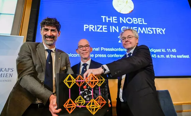 From left, Chair of the Nobel Committee for Chemistry Heiner Linke, Secretary General of the Swedish Academy of Sciences Hans Ellegren, and Member of the Nobel Committee for Chemistry Olof Ramstrom pose after announcing Susumu Kitagawa, Richard Robson and Omar Yaghi as the recipients the Nobel Prize in Chemistry, at the Nobel Assembly of the Karolinska Institutet, in Stockholm, Sweden, Wednesday, Oct. 8, 2025. (Fredrik Sandberg/TT News Agency via AP)