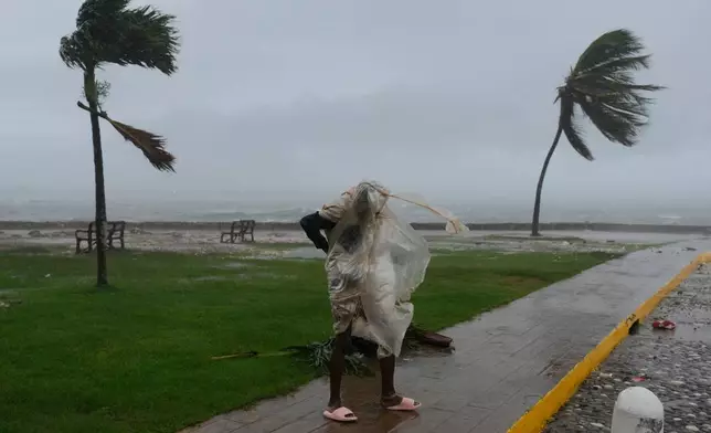 A man walks in Kingston, Jamaica, as Hurricane Melissa approaches, Tuesday, Oct. 28, 2025. (AP Photo/Matias Delacroix)