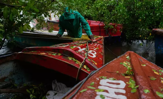 A fisherman ties boats in preparation for the forecasted arrival of Hurricane Melissa in Old Harbour, Jamaica, Monday, Oct. 27, 2025. (AP Photo/Matias Delacroix)