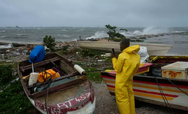 A man watches the coastline in Kingston, Jamaica, as Hurricane Melissa closes in, Tuesday, Oct. 28, 2025. (AP Photo/Matias Delacroix)