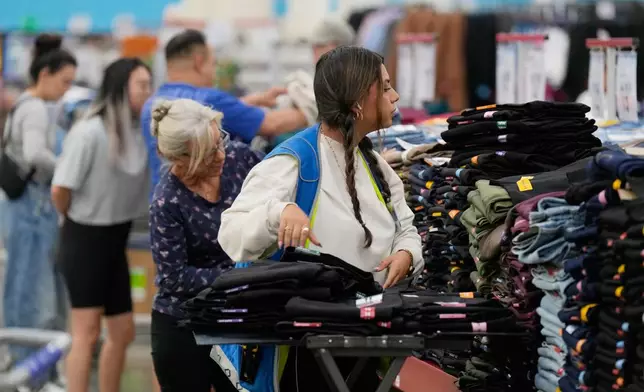 A worker stocks a display of clothing at a Sam's Club, Wednesday, Sept. 24, 2025, in Bentonville, Ark. (AP Photo/Charlie Riedel)