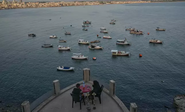 A Syrian couple smoke "shisha" water pipe at Latakia's Mediterranean seaside corniche, in the coastal city of Latakia, Syria, Saturday, Oct. 4, 2025. (AP Photo/Hussein Malla)