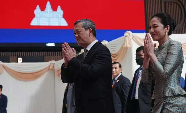 Cambodian Prime Minister Hun Manet, left, greets his officers together with his wife Pich Chanmony as they inaugurate Techo International Airport in Kandal province, Cambodia, Monday, Oct. 20, 2025. (AP Photo/Heng Sinith)