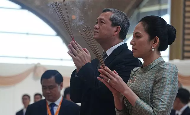 Cambodian Prime Minister Hun Manet, front left, prays together with his wife Pich Chanmony to inaugurate Techo International Airport in Kandal province, Cambodia, Monday, Oct. 20, 2025. (AP Photo/Heng Sinith)