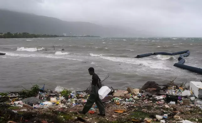 A man walks along the coastline during the passing of Hurricane Melissa in Kingston, Jamaica, Tuesday, Oct. 28, 2025. (AP Photo/Matias Delacroix)