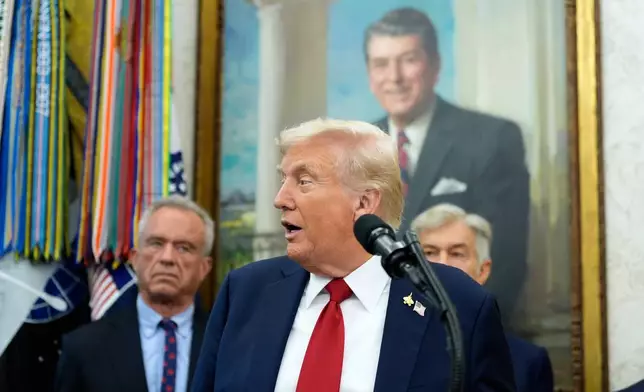 President Donald Trump speaks in the Oval Office of the White House, Tuesday, Sept. 30, 2025, in Washington. Behind the President are Secretary of Health and Human Services Robert F. Kennedy, Jr., left, and Mehmet Oz, Administrator for the Centers for Medicare &amp; Medicaid Services. (AP Photo/Alex Brandon)