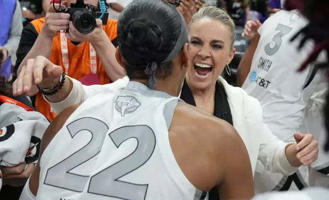 Las Vegas Aces head coach Becky Hammon, right, and A'ja Wilson (22) celebrate after defeating the Phoenix Mercury in Game 4 of the WNBA basketball finals, Friday, Oct. 10, 2025, in Phoenix. (AP Photo/Rick Scuteri)