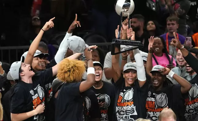 Las Vegas Aces center A'ja Wilson holds up the championship trophy after defeating the Las Vegas Aces in Game 4 of the WNBA basketball finals, Friday, Oct. 10, 2025, in Phoenix. (AP Photo/Rick Scuteri)