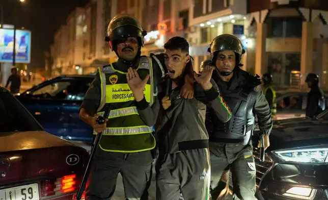 A boy is detained as youth led protests calling for healthcare and education reforms turned violent, in Sale, Morocco, Wednesday, Oct. 1, 2025. (AP Photo/Mosa'ab Elshamy)