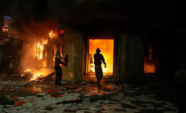 People torch and loot a bank as youth led protests calling for healthcare and education reforms turned violent, in Sale, Morocco, Wednesday, Oct. 1, 2025. (AP Photo/Mosa'ab Elshamy)