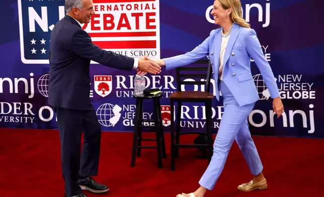 FILE - Republican candidate Jack Ciattarelli, left, shake hands with Democratic candidate for governor Mikie Sherrill, right, before a gubernatorial debate Sept. 21, 2025, in Lawrenceville, N.J. (AP Photo/Noah K. Murray, File)
