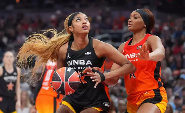 FILE - Chicago Sky's Angel Reese, left, shoots against Washington Mystics' Kiki Iriafen during the second half of a WNBA All-Star basketball game, July 19, 2025, in Indianapolis. (AP Photo/Michael Conroy, File)