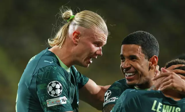 Manchester City's Erling Haaland, left, celebrates with teammates after scoring his side's opening goal during the Champions League opening phase soccer match between Villarreal and Manchester City in Villarreal, Spain, Tuesday, Oct. 21, 2025. (AP Photo/Alberto Saiz)