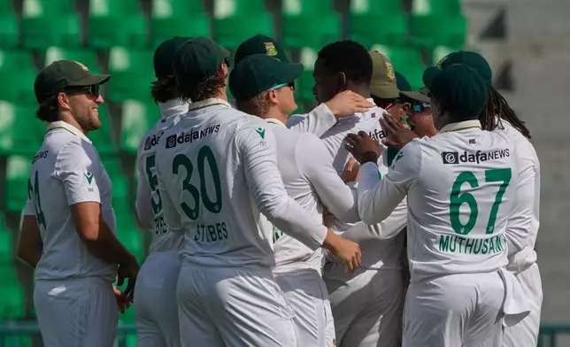 South Africa's Kagiso Rabada, center, celebrates with teammates after taking the wicket of Pakistan's Abdullah Shafique during the first day of of first test cricket match between Pakistan and South Africa, in Lahore, Pakistan, Sunday, Oct. 12, 2025. (AP Photo/K.M. Chaudary)