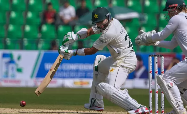 Pakistan's Imam-ul-Haq, center, plays a shot during the first day of of first test cricket match between Pakistan and South Africa, in Lahore, Pakistan, Sunday, Oct. 12, 2025. (AP Photo/K.M. Chaudary)