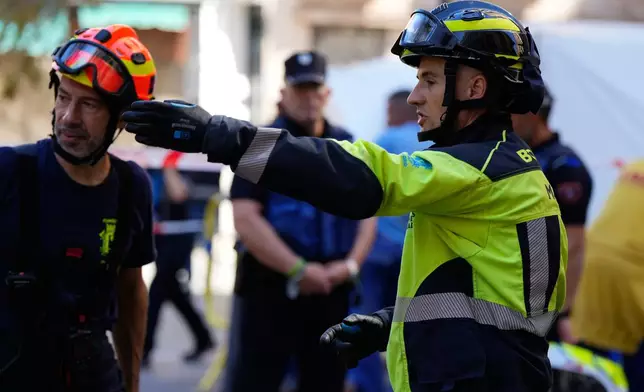 Emergency personnel respond to the scene of a building collapse in Madrid, Spain, on Tuesday, Oct. 7, 2025. (AP Photo/Manu Fernandez)