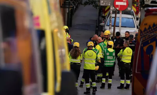 Emergency personnel respond to the scene of a building collapse in Madrid, Spain, on Tuesday, Oct. 7, 2025. (AP Photo/Manu Fernandez)