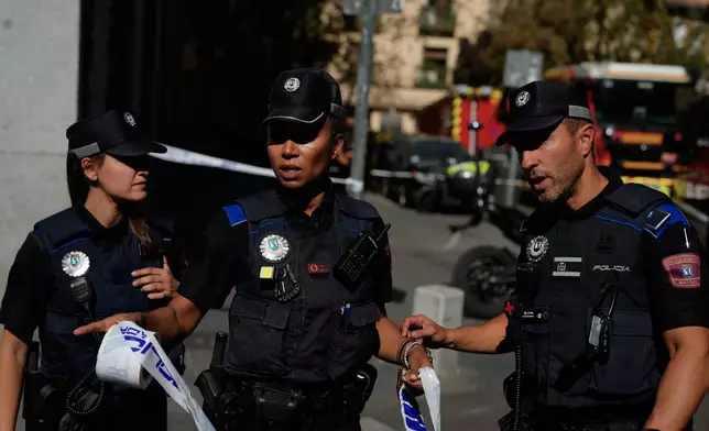 Police rope off an area as emergency personnel respond to the scene of a building collapse in Madrid, Spain, on Tuesday, Oct. 7, 2025. (AP Photo/Manu Fernandez)