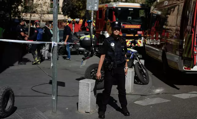 Police rope off an area as emergency personnel respond to the scene of a building collapse in Madrid, Spain, on Tuesday, Oct. 7, 2025. (AP Photo/Manu Fernandez)
