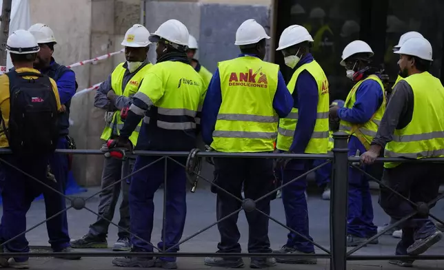 Emergency personnel respond to the scene of a building collapse in Madrid, Spain, on Tuesday, Oct. 7, 2025. (AP Photo/Manu Fernandez)