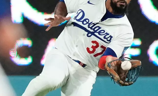 Los Angeles Dodgers right fielder Teoscar Hernández makes a catch on a fly ball from Philadelphia Phillies' Bryce Harper during the seventh inning in Game 3 of baseball's National League Division Series Wednesday, Oct. 8, 2025, in Los Angeles. (AP Photo/Mark J. Terrill)
