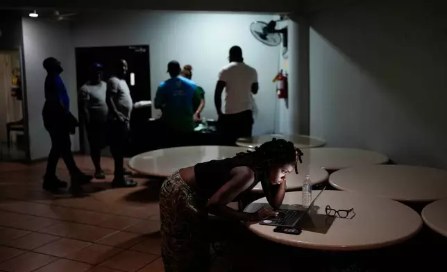 A woman video chats with a friend ahead of Hurricane Melissa's forecast arrival in Kingston, Jamaica, Monday, Oct. 27, 2025. (AP Photo/Matias Delacroix)