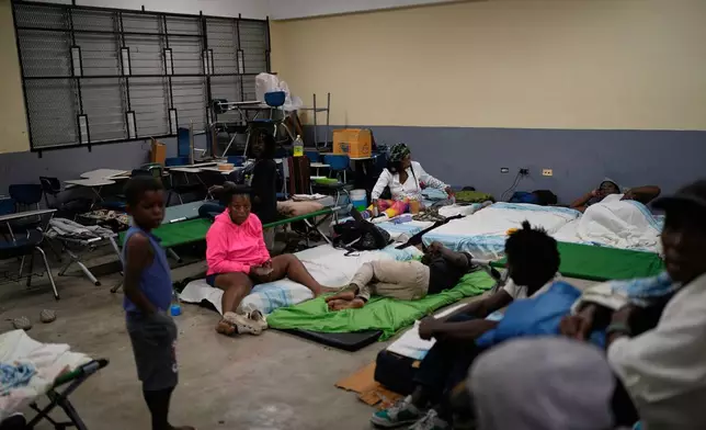 People take shelter in a school ahead of Hurricane Melissa's forecast arrival in Old Harbour, Jamaica, Monday, Oct. 27, 2025. (AP Photo/Matias Delacroix)