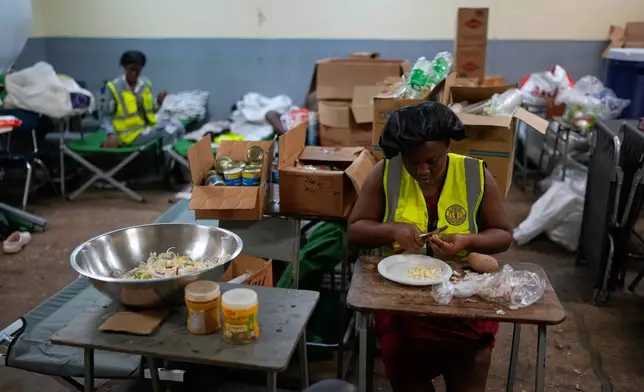 Cooks prepare meals at a shelter set up in a school ahead of Hurricane Melissa's forecast arrival in Old Harbour, Jamaica, Monday, Oct. 27, 2025. (AP Photo/Matias Delacroix)