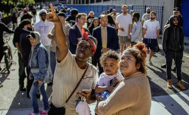 People take a look at part of a building that collapsed in the Bronx borough of New York, Wednesday, Oct. 1, 2025. (AP Photo/Eduardo Munoz Alvarez)