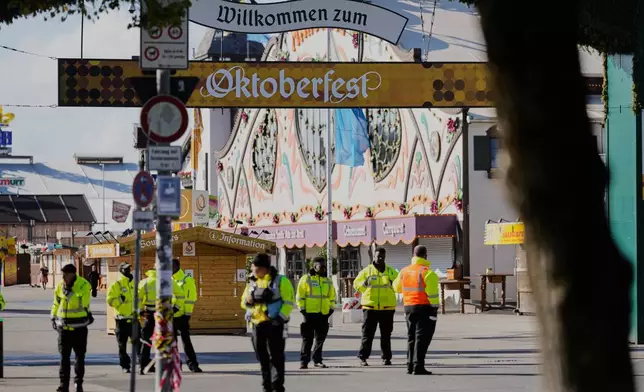Security people stand on the area of the Oktoberfest that stays closed after a bomb threatening in Munich, Germany, Wednesday, Oct.1, 2025. (AP Photo/Matthias Schrader)