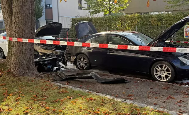 Burned cars are seen in a street after a fire in Munich, Germany, Wednesday, Oct. 1, 2025. (Roland Freund/dpa via AP)