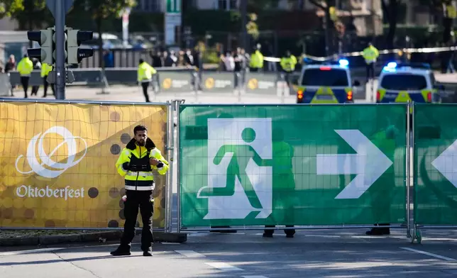 A man stands at the fence of the Oktoberfest area that stays closed after a bomb threatening in Munich, Germany, Wednesday, Oct.1, 2025. (AP Photo/Matthias Schrader)