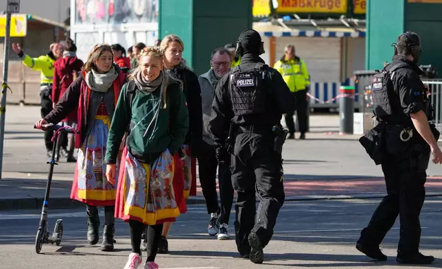 A police officer walks at the Oktoberfest area that stays closed after a bomb threatening in Munich, Germany, Wednesday, Oct.1, 2025. (AP Photo/Matthias Schrader)