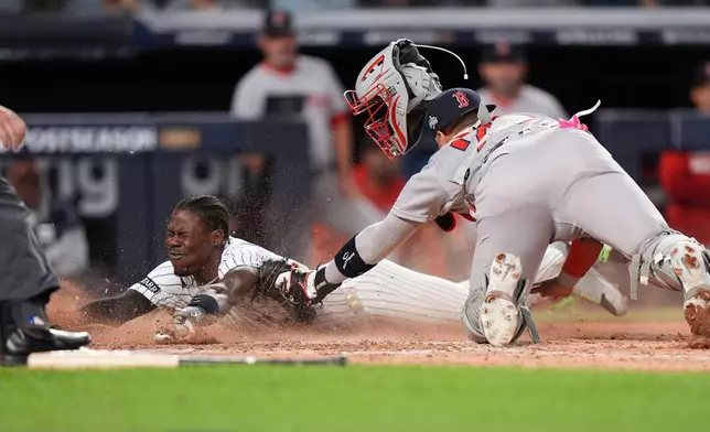 New York Yankees Jazz Chisholm Jr. slides safely into home plate ahead of the tag from Boston Red Sox catcher Carlos Narváez (75) during the eighth inning of Game 2 of an American League wild-card baseball playoff series, Wednesday, Oct. 1, 2025, in New York. (AP Photo/Frank Franklin II)