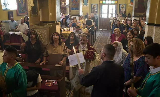 Greek Orthodox parish priest David Khoury attends morning Mass at St. George church in the West Bank village of Taybeh, Sept. 28, 2025. (AP Photo/Leo Correa)
