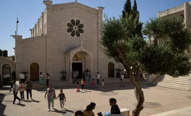 Palestinian parishioners stand outside Christ the Redeemer Church after attending a morning Mass in the West Bank village of Taybeh, Sept. 28, 2025. (AP Photo/Leo Correa)