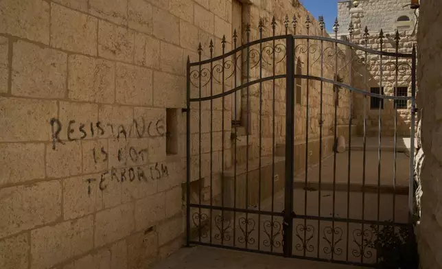 A message of resistance is written in English on a wall of an alley in the Old City of Taybeh, in the West Bank, Sept. 28, 2025. (AP Photo/Leo Correa)
