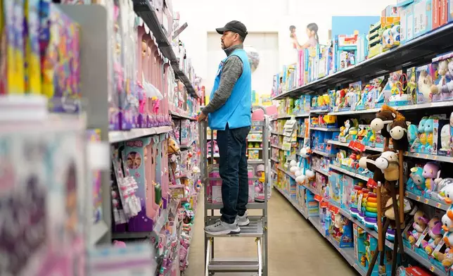 FILE - An employee stocks shelves in the toy section of a Walmart in Secaucus, N.J., Tuesday, Nov. 22, 2022. (AP Photo/Seth Wenig, File)