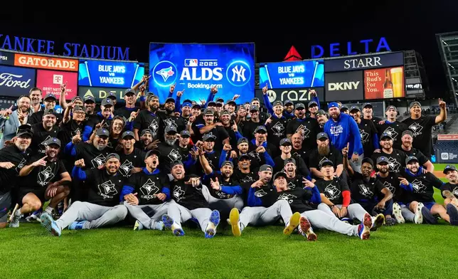 The Toronto Blue Jays gather for a group photo on the field after beating the New York Yankees in Game 4 of baseball's American League Division Series, Wednesday, Oct. 8, 2025, in New York. (AP Photo/Yuki Iwamura)