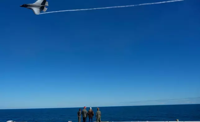 President Donald Trump and first lady Melania Trump watch a naval sea power demonstration, part of the Navy's 250th anniversary celebration, aboard the USS George H.W. Bush aircraft carrier in the Atlantic Ocean off the coast of Norfolk, Va., Sunday, Oct. 5, 2025. (AP Photo/Alex Brandon)