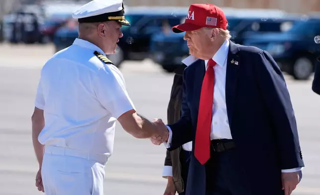 President Donald Trump greets Cape. Matt Schliemann, commanding officer of Naval Station Norfolk as he and first lady Melania Trump arrive on Air Force One at Naval Station Norfolk Chambers Field in Norfolk, Va., Sunday, Oct. 5, 2025. (AP Photo/Alex Brandon)