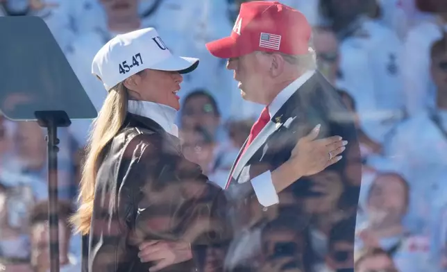 President Donald Trump greets first lady Melania Trump as he arrives to speak during a celebration for the 250th anniversary of the U.S. Navy aboard the USS Harry S. Truman at Naval Station Norfolk, Sunday Oct. 5, 2025 in Norfolk, Va. (AP Photo/Steve Helber)