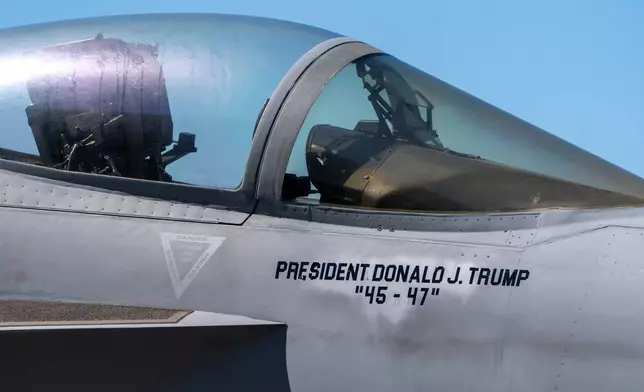 An F/A-18E fighter jet with President Donald Trump's name stenciled onto is seen aboard the USS George H.W. Bush aircraft carrier in the Atlantic Ocean off the coast of Norfolk, Va., Saturday, Oct. 4, 2025. (AP Photo/Alex Brandon, Pool)