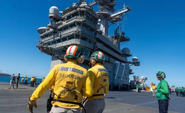 Crew members stand on the flight deck aboard the USS George H.W. Bush aircraft carrier in the Atlantic Ocean off the coast of Norfolk, Va., Saturday, Oct. 4, 2025. (AP Photo/Alex Brandon, File)