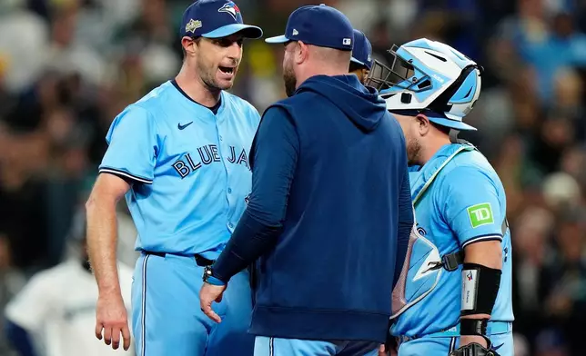 Toronto Blue Jays pitcher Max Scherzer (31) shares some words with Toronto Blue Jays manager John Schneider during a visit to the mound in fifth inning MLB American League Championship Series game 4 baseball action against the Seattle Mariners, in Seattle, Thursday, Oct. 16, 2025. (Frank Gunn/The Canadian Press via AP)