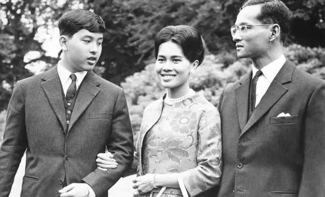 FILE - King Bhumibol of Thailand, right, walks with his wife Queen Sirikit, center, and their 13-year-old son Crown Prince Vajiralongkorn through the gardens of their residence at Sunninghill, Berkshire, July 27, 1966, where they are staying during their private visit to Britain. (AP Photo/Harris, File)