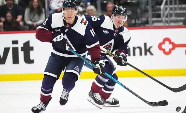 Colorado Avalanche center Jack Drury, front, collects the puck as left wing Victor Olofsson follows in the first period of an NHL hockey game against the Dallas Stars, Saturday, Oct. 11, 2025, in Denver. (AP Photo/David Zalubowski)