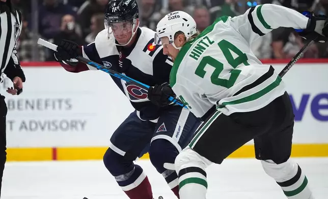 Colorado Avalanche center Brock Nelson (11) and Dallas Stars center Roope Hintz (24) fight for control of the puck in the first period of an NHL hockey game Saturday, Oct. 11, 2025, in Denver. (AP Photo/David Zalubowski)